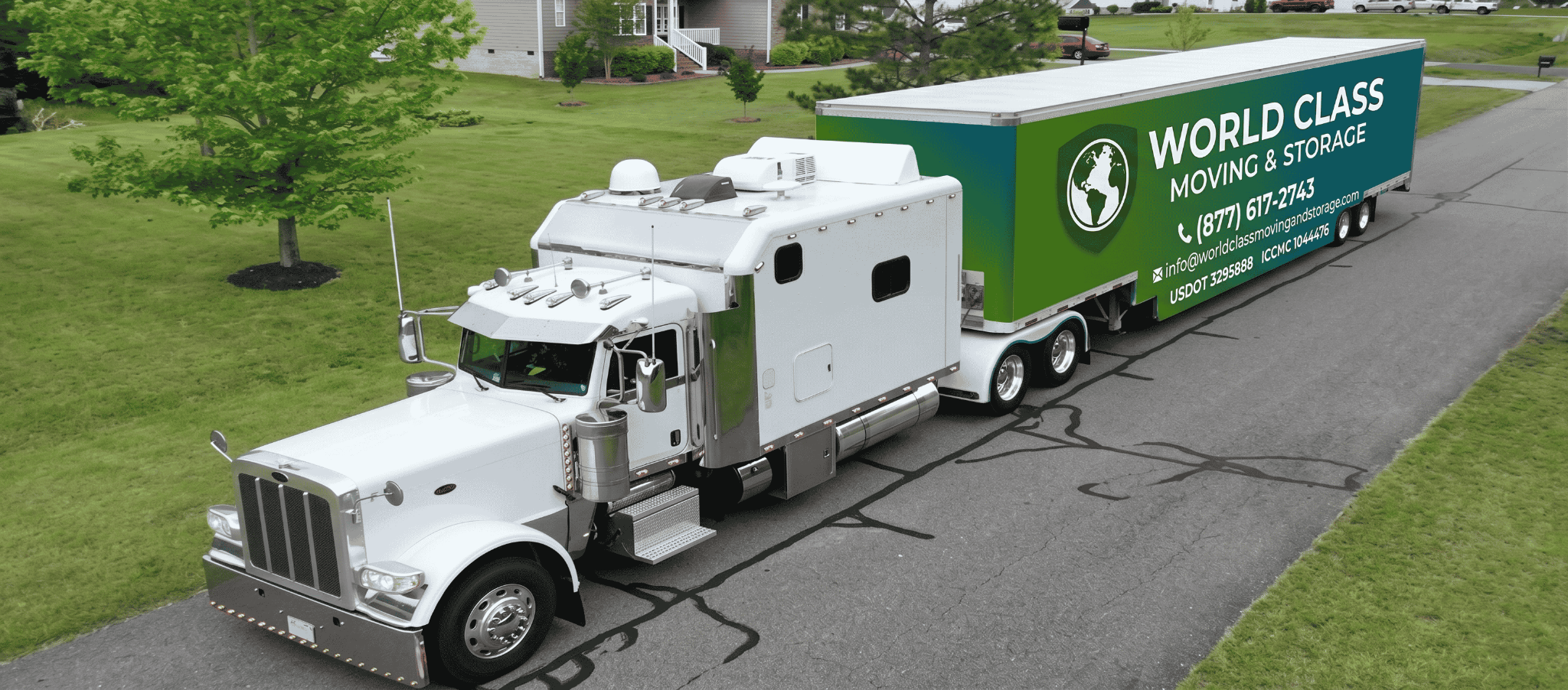 World Class Moving & Storage truck and trailer on the road with a branded cross-country moving banner
